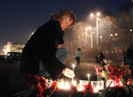 A woman lights a candle in Kiev in memory of protesters who died